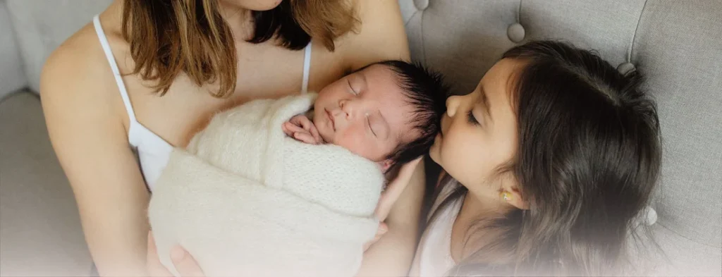 sibling kissing baby